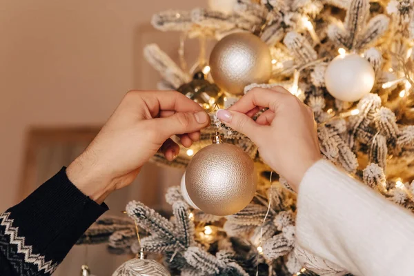 可爱的年轻夫妇装饰圣诞树亲吻拥抱家舒适的室内空气新年派对庆祝概念冬季花环的夜晚 — 图库照片