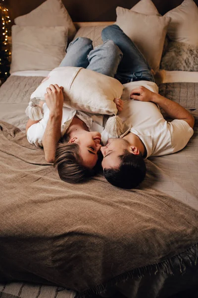 Vertikal Bild Härlig Ung Romantisk Par Liggande Sängen Girlanger Kysser — Stockfoto