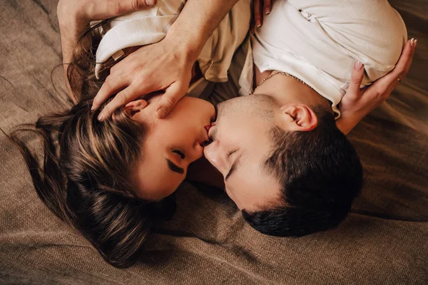 Bella Giovane Coppia Romantica Sdraiata Ghirlande Letto Baciare Abbracciare Casa — Foto Stock