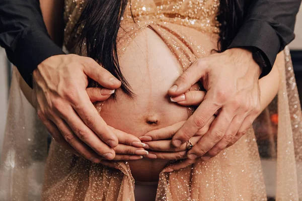 男人和女人抱着圆圆的肚子 里面有小孩 怀孕的夫妇在等婴儿 丈夫摸他妻子的手 怀孕的新生儿 未来家庭 — 图库照片