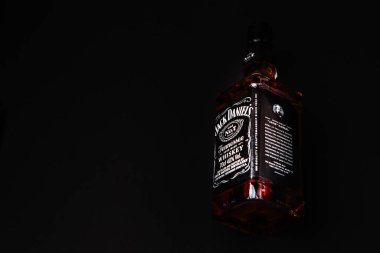 Khmelnytskyi, Ukrayna - 22 Kasım 2022: Glass bottle of American brand of New Tennessee Whiskey Jack Daniel 's, Jack Daniel Distillery on dark background, copy space. En çok satan alkol