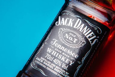 Khmelnytskyi, Ukrayna - 22 Kasım 2022: Glass bottle of American brand of New Tennessee Whiskey Jack Daniel 's, Jack Daniel Distillery on red and blue background, copy space. En çok satan alkol