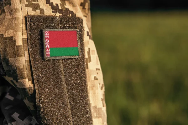 Close up millitary woman or man shoulder arm sleeve with Belarus flag patch. Belarus troops army, soldier camouflage uniform. Armed Forces, empty copy space for text