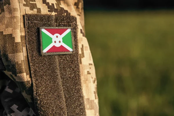 Close up millitary woman or man shoulder arm sleeve with Burundi flag patch. Burundi troops army, soldier camouflage uniform. Armed Forces, empty copy space for text