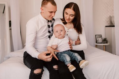 Little boy pop-eyed surprised cute child baby playing with parents, sitting on knees. Playful shocked toddler with bulging eyes having fun, making faces grimaces. Happy childhood, family concept