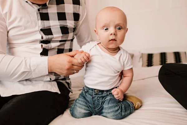 Little boy happy funny smiling laughing kid cute child baby playing with parents, crawling on the coach. Playful toddler with bulging eyes making faces grimaces. Happy childhood, family concept