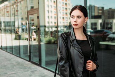 Pretty brunette caucasian woman dressed leather suit with shoulder bag walking outside street. Businesswoman hurry to work. Office CEO clerk. Confident serious lady. Professional business owner