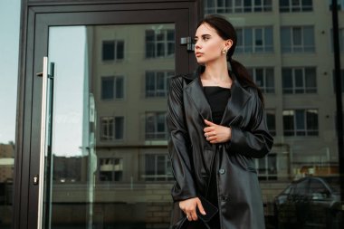 Pretty brunette caucasian woman dressed leather suit with shoulder bag walking outside street. Businesswoman hurry to work. Office CEO clerk. Confident serious lady. Professional business owner