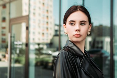 Pretty brunette caucasian woman dressed leather suit with shoulder bag walking outside street. Businesswoman hurry to work. Office CEO clerk. Confident serious lady. Professional business owner