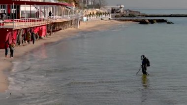 Odessa, Ukrayna 14.04.2023. Güneşli bir bahar sabahı, Odessa Arcadia 'daki Karadeniz sahilinde hazine avcısı.