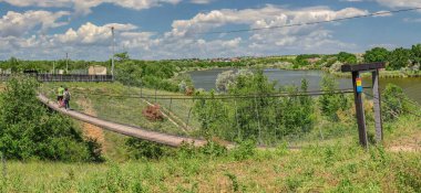 Odessa, Ukrayna 06.06.2023. Güneşli bir yaz gününde Odessa, Ukrayna 'daki Eco Park' taki asma köprü.