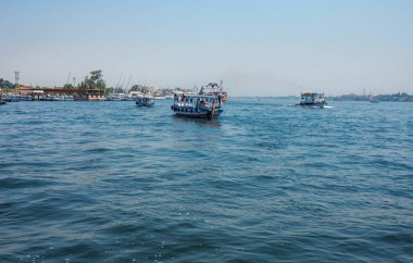 Luxor, Mısır - 27.07.2025. Nil Nehri manzaralı kıyı şeridi boyunca oteller ve binalar ve açık mavi bir gökyüzü.