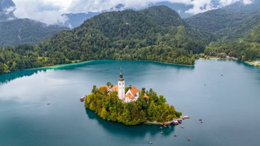 Arka planda şatosu ve pletna botları olan Bled Island, Slovenya