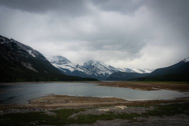 Mountain lake landscape under a dramatic sky, captured on a cloudy day.