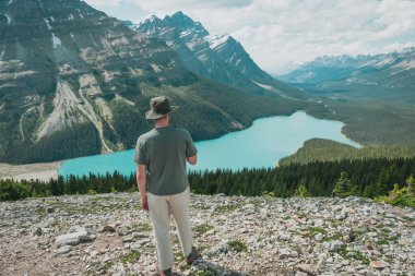 Person admiring lake in mountain range. Breathtaking view of nature.