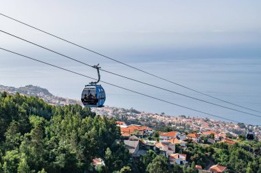 view of Funchal with traditional cable car above the city, in Madeira island vacation tourism landscape panorama.