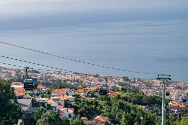 view of Funchal with traditional cable car above the city, in Madeira island vacation tourism landscape panorama.