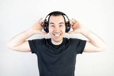 Genç erkek manken kulaklık takıyor. Havalı moda tarzı. Mutlu görünüyor..