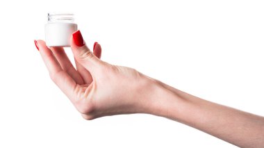 Beyaz arka planda izole edilmiş bir krema kavanozunu tutan kadın eli. Yüksek kalite fotoğraf