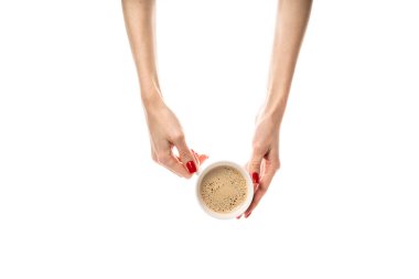 Kadın eli beyaz arka planda beyaz bir seramik bardak tutuyor. Taze kırmızı manikürlü kadın elleri. Beyaz arka planda izole edilmiş. Yüksek kalite fotoğraf