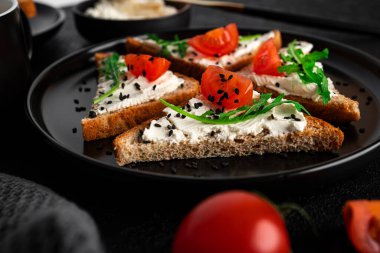 Koyu arkaplanda krem peynirli ve sebzeli Hughchetta. Kadeh kaldırma ve kahve. Sandviç. Sebzeli ve peynirli sandviç. Yüksek kalite fotoğraf