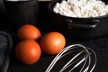 Koyu arkaplanda süzme peynir güveci pişirme işlemi. Yumurta, süzme peynir, irmik, şeker. Curd güveci. Yüksek kalite fotoğraf