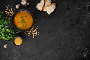 Arka planda bezelye çorbası. Siyah tencerede çorba var. Bir kase çorba. Maydanoz, biber, sos, ekmek. Yüksek kalite fotoğraf