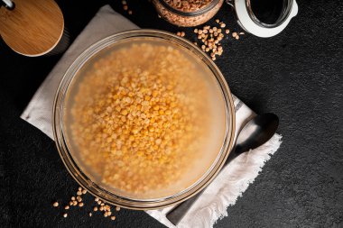 Koyu arkaplanda bir kase kurutulmuş bezelye. Sırılsıklam olmuş bezelyeler. Yüksek kalite fotoğraf