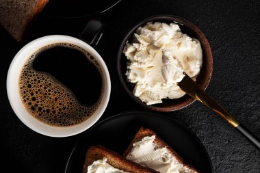 Koyu arkaplanlı krem peynirli Kadeh kaldırma ve kahve. Sandviç. Sebzeli ve peynirli sandviç. Yüksek kalite fotoğraf