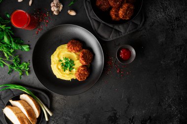 Kaburgalı patates püresi, domates suyu ve karanlık bir arka planda otlar. Yüksek kalite fotoğraf