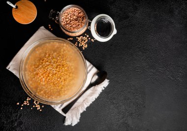 Koyu arkaplanda bir kase kurutulmuş bezelye. Sırılsıklam olmuş bezelyeler. Yüksek kalite fotoğraf
