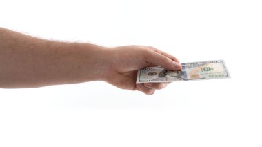 Tarafsız bir ortamda bir el 100 dolarlık banknot uzatır, bir alışveriş ya da hediye alışverişini gösterir. Avucundaki paranın keskin detaylarına odaklanıyoruz..