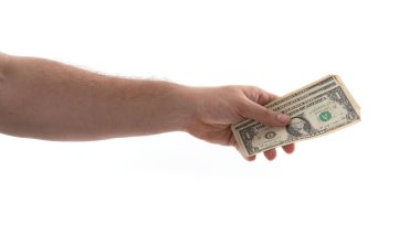 Bir kişi bir avuç dolusu nakit tutar, muhtemelen bir mali işlemde ödeme yapar. Değiş tokuşa odaklanarak ticareti ve günlük etkileşimleri sembolize ediyor..