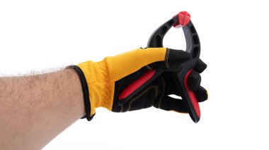 Sarı iş eldiveni takan bir el, genellikle ahşap işçiliğinde kullanılan siyah ve kırmızı klemp aletini kavrar. Bu araç, montaj ve inşaat sırasında malzemelerin korunması için gereklidir.