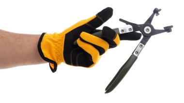 Eldivenli bir el, metal parçaları olan, işe hazır yeşil bir bahçe aletini tutuyor. İşlevsellik ve parlak eldiven üzerinde duruluyor. Bahçe bakımı faaliyetleri öneriliyor..