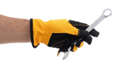 Siyah ve sarı iş eldiveni giyen biri parlak bir ingiliz anahtarı tutar ve tamir etmeye hazırdır. Arkaplan tarafsız, aracı ve eli vurguluyor.