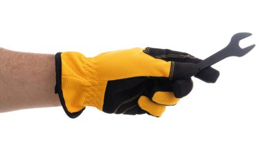 Eldivenli bir el, inşaat ve mekanik işlerde sıklıkla kullanılan siyah bir İngiliz anahtarını sıkıca kavrar. Parlak eldivenlerde güvenlik ve görevlere hazırlık vurgulanıyor.