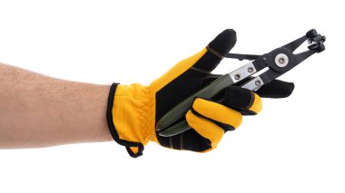 Sarı ve siyah eldiven giyen bir el, metal çeneli hassas bir aleti kavrar. Bu araç muhtemelen bir atölye veya inşaat ayarlarında karmaşık görevler için kullanılır.