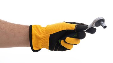 Eldivenli bir el ingiliz anahtarını sıkıca kavrıyor, bakım ve onarım için hazırlık yapıyor. Sarı ve siyah eldivenler güvenlik ve görevlere hazır olduğunu gösteriyor..