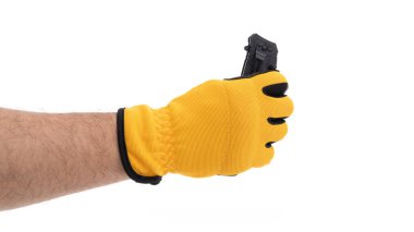 Sarı eldiven takan bir el siyah bir objeyi sıkıca kavrar. Bu da güvenlik ve hassasiyete odaklandığını gösterir. Arkaplan sade, yapılan eylemi vurguluyor.