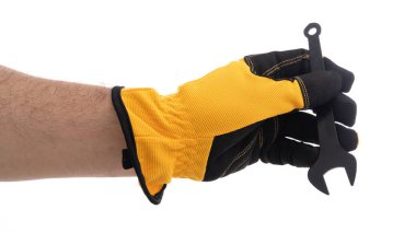 Eldivenli bir el ingiliz anahtarı aletini sıkıca kavrıyor. Eldiven, mekanik görevler sırasında güvenlik ve dayanıklılığa odaklandığını gösteren, dokulu siyah bir yüzeye sahip parlak sarı bir renge sahiptir..