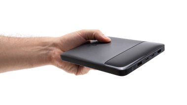 Bir kişi parlak, siyah, taşınabilir bir dış depolama cihazı tutuyor. Bireyler aygıtları birden fazla portta gösteriyor, veri transferi ve depolama işlevselliğini gösteriyor.