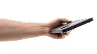 Bir insan, birden fazla portu gösteren modern bir aleti tutmak için elini uzatır. El ve teknoloji arasındaki etkileşimi vurguluyor, parlak bir tasarım ve işlevsellik sergiliyor.