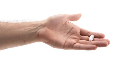 Damarları görünen bir el nazikçe küçük beyaz bir hap tutar. Yumuşak doğal ışık, elin ve hapın hatlarını belirginleştirir ve sakin bir atmosfer yaratır..