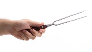 Bir el, ahşap saplı sağlam bir çatalı kavrar ve yemek hazırlığında kullanılmaya hazırdır. Etle ve diğer yemeklerle başa çıkmak için tasarlanmış keskin uçlarının vurgulandığı araç üzerinde duruluyor.