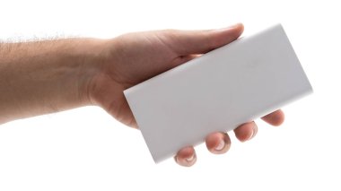 Bir el, beyaz dikdörtgen bir nesneyi tutmak için uzanıyor. Bu da yaklaşan bir değiş tokuşu işaret ediyor. Odak noktası, bir ögeyi verme veya alma hareketini vurgular.