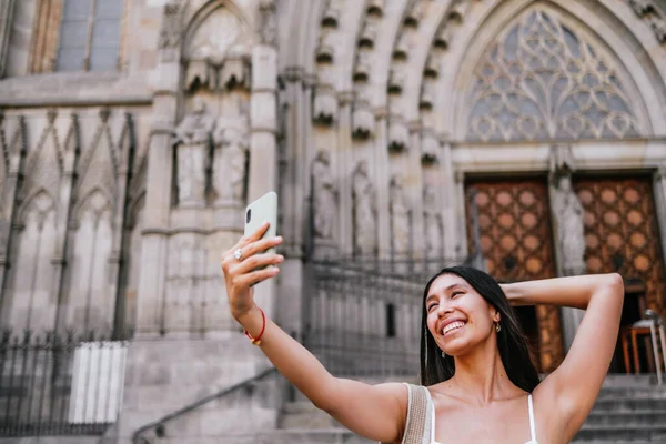 Αισιόδοξη Λατινοαμερικανίδα Που Αγγίζει Κεφάλι Και Χαμογελά Ενώ Βγάζει Selfie — Φωτογραφία Αρχείου