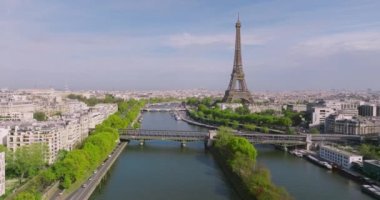 Paris şehir merkezinin havadan görüntüsü. Bir İHA Seine Nehri üzerinden Eyfel Kulesi 'ne doğru uçuyor. Fransa 'nın başkentini yeşil ağaçlar süslüyor. Paris 'te güneşli bir gün. Yüksek kalite 4k görüntü