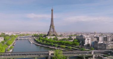 Paris şehir merkezinin havadan görüntüsü. Bir İHA Seine Nehri üzerinden Eyfel Kulesi 'ne doğru uçuyor. Fransa 'nın başkentini yeşil ağaçlar süslüyor. Paris 'te güneşli bir gün. Yüksek kalite 4k görüntü