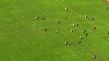 Kamera, profesyonellerin koşup birbiriyle rekabet ettiği yeşil futbol sahasının üzerinde uçuyor. İHA 'nın parallaks etkisi olan bir futbol maçı..
